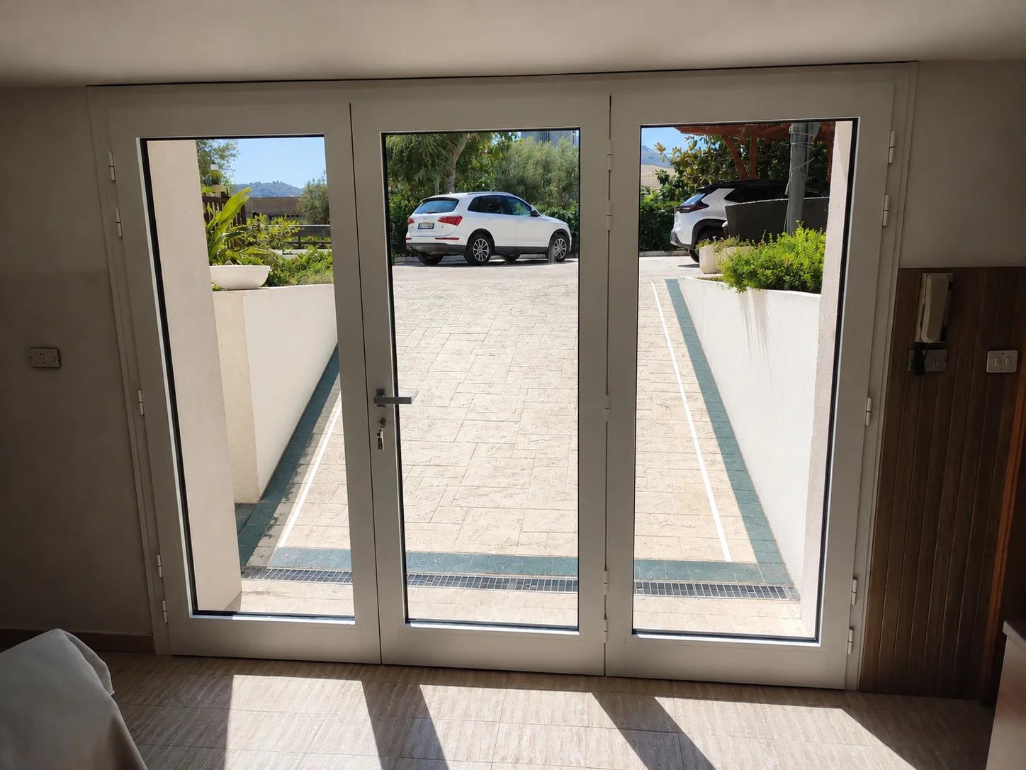Porta finestra a tre ante in alluminio bianco con vista giardino - installazione IS Metal srl Abruzzo